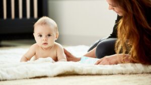 baby lying on carpet with mother lying beside