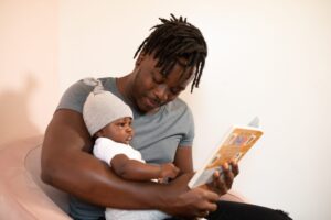 Artikel om sömnproblem hos barn. Pappa läser saga för sitt barn.